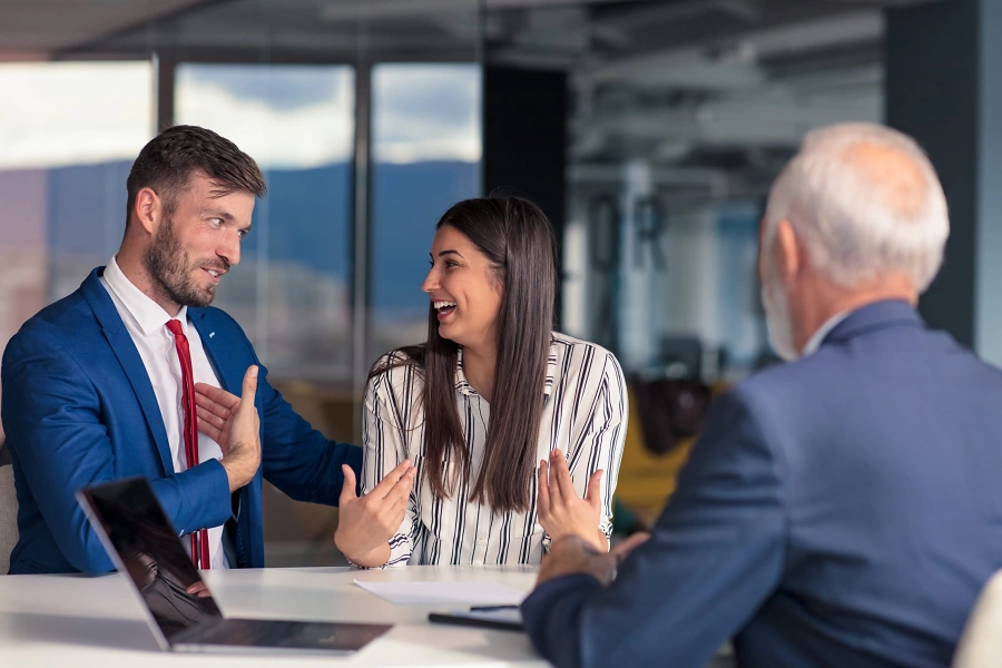 Couple talking with an advisor across a meeting table, representing the first conversation when buying a home in Whitney